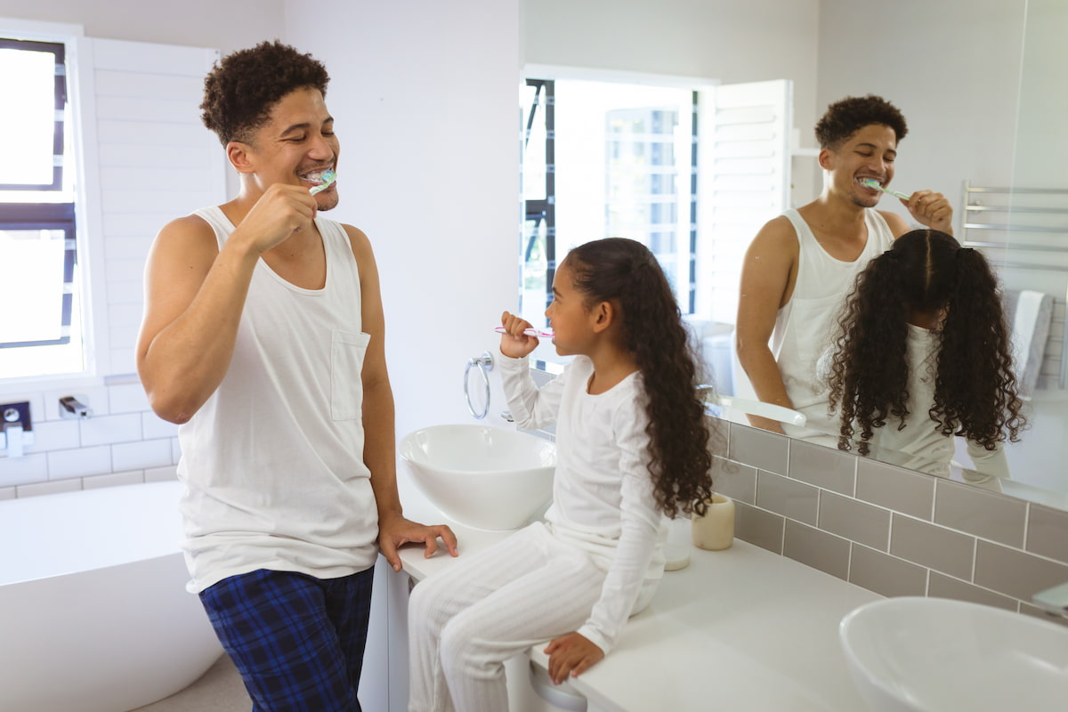 padre e hija cepillándose los dientes